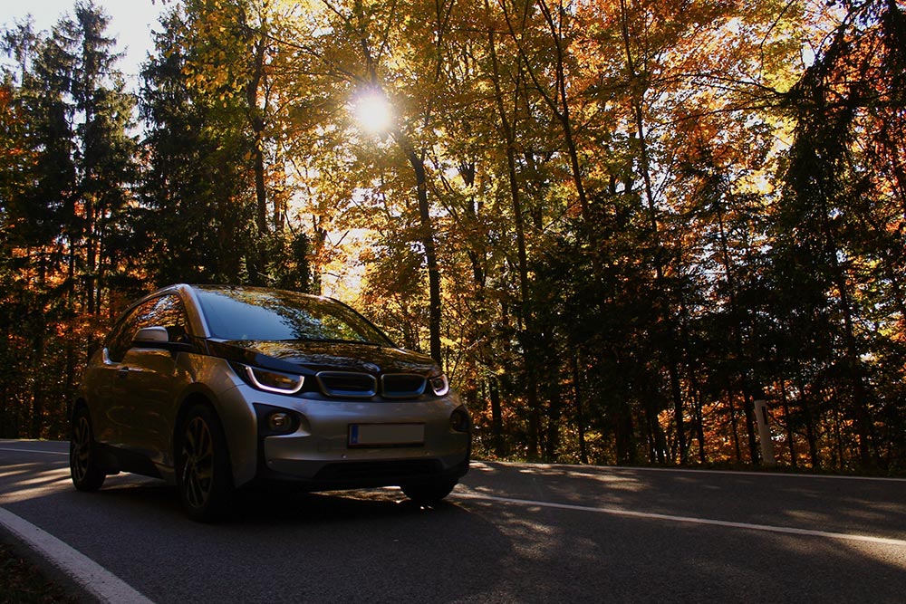 Electric car driving on country road